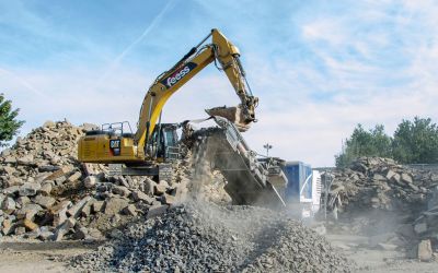 Bagger befüllt den Brecher mit Beton